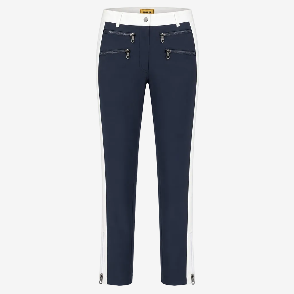 A pair of navy blue cropped pants with white side panels, featuring silver zipper details on the front and along the lower hems, shown against a plain white background.