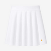A white pleated athletic skirt with a small gold circular logo on the lower right hem, shown against a plain white background.