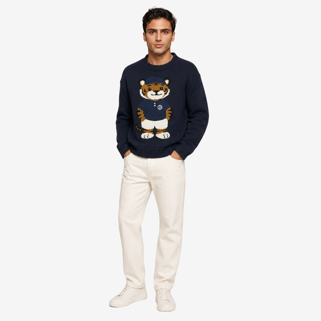 Man wearing a navy sweater with a tiger design on a plain background