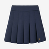 A navy blue pleated athletic skirt with a wide waistband and a small gold circular logo on the lower right hem, shown against a plain white background.