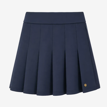 A navy blue pleated athletic skirt with a wide waistband and a small gold circular logo on the lower right hem, shown against a plain white background.