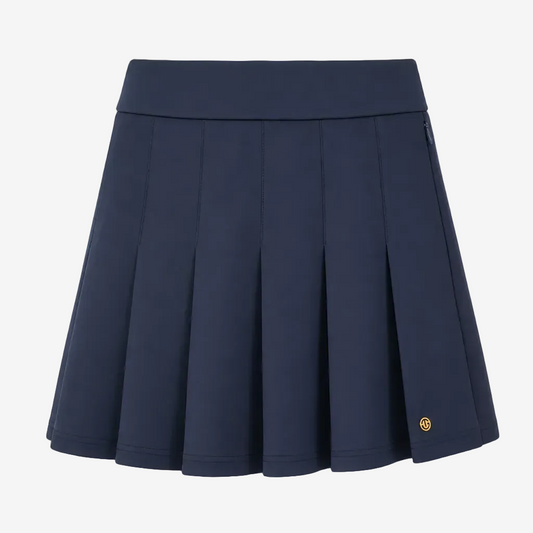 A navy blue pleated athletic skirt with a wide waistband and a small gold circular logo on the lower right hem, shown against a plain white background.