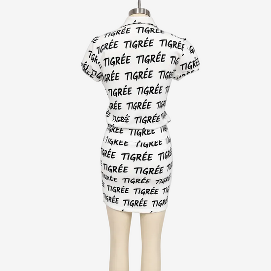 White dress with black text on a mannequin against a white background