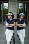 Woman in golf attire standing in front of a glass door with a reflection.
