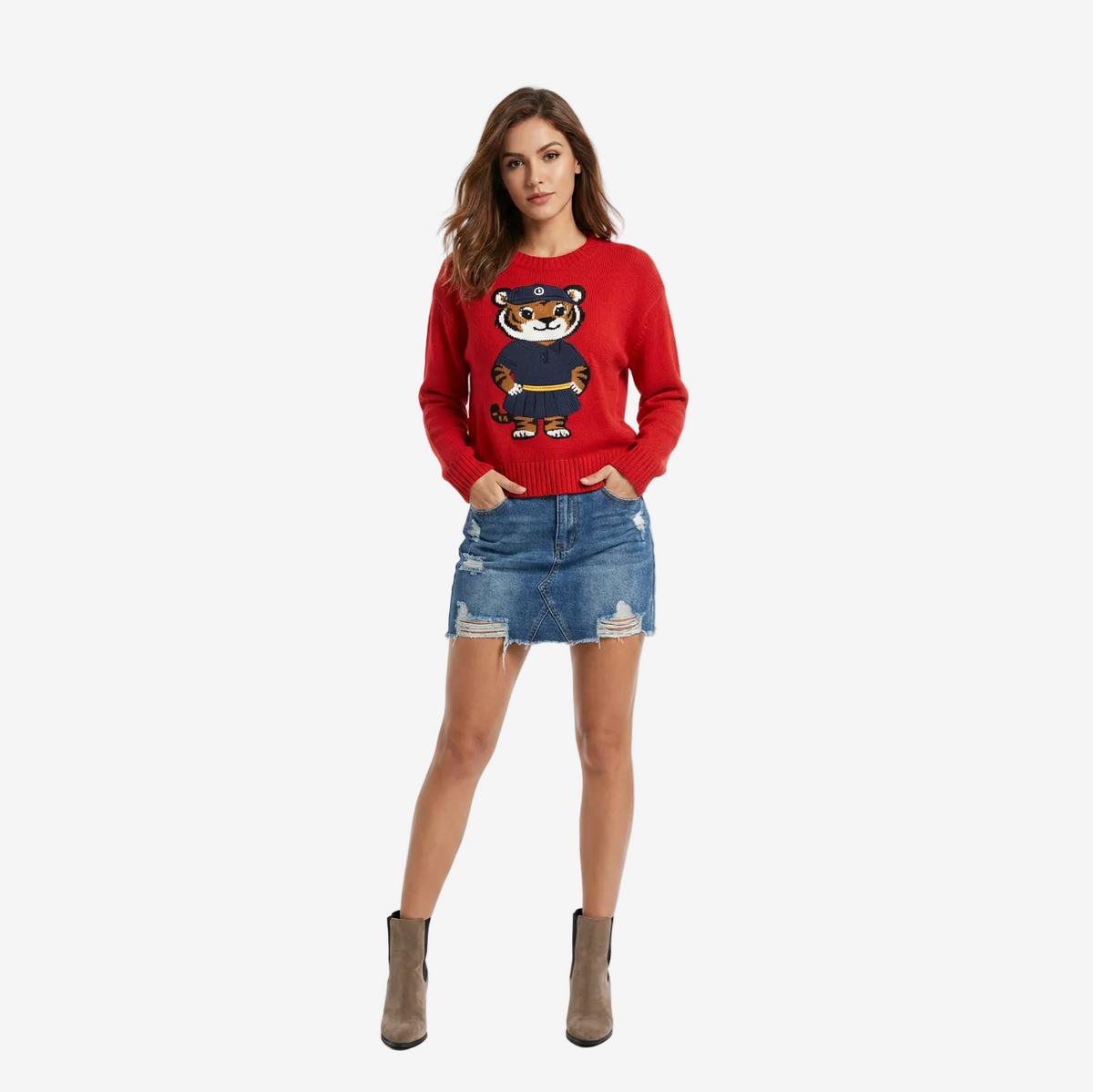 Woman wearing a red sweater with a tiger design and a denim skirt on a white background