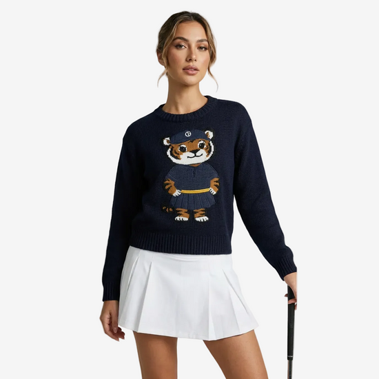 Woman wearing a navy sweater with a tiger design on a white background