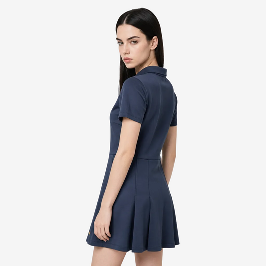 A woman modeling a short-sleeve navy blue dress with a collared neckline and a flared skirt, photographed against a plain light gray studio background.