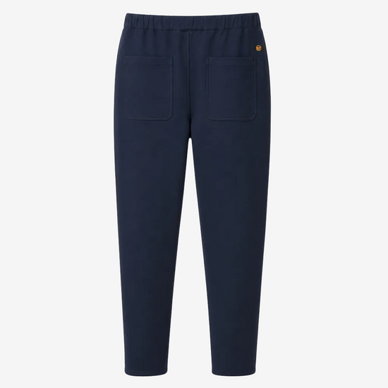 A pair of navy blue cropped pants with an elastic waistband, two large front patch pockets, and a small yellow embroidered logo on the upper right hip, shown against a plain white background.