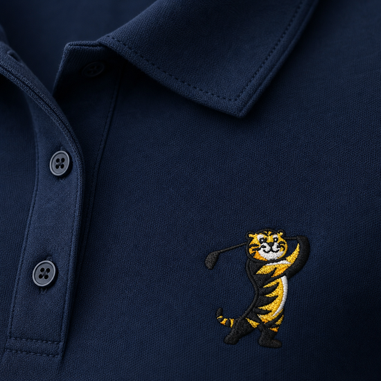 Close-up of a navy blue polo shirt featuring a small embroidered tiger mascot on the left chest, with the collar and button placket visible.