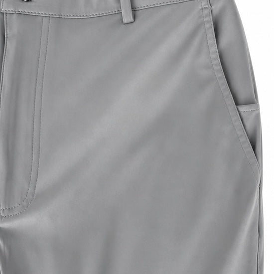 Close-up of light gray trousers showing the waistband with a button closure, belt loops, front seam, and side pocket.