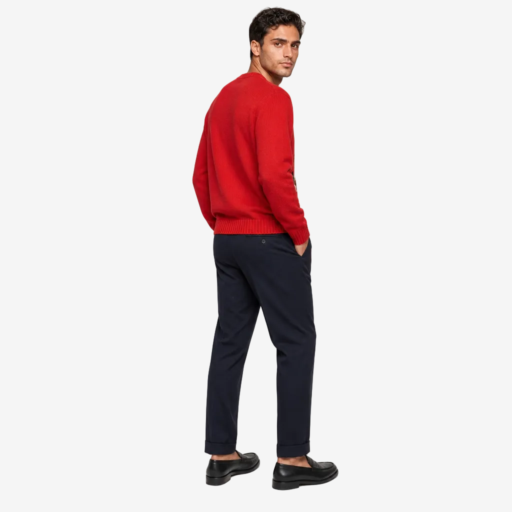 Man wearing a red sweater and black pants on a light gray background