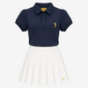 A girls' two-piece uniform set featuring a navy blue short-sleeve polo shirt with a small embroidered tiger logo on the left chest, paired with a white pleated skirt. The collar label and the skirt hem both display the 'TIGRE' brand logo.