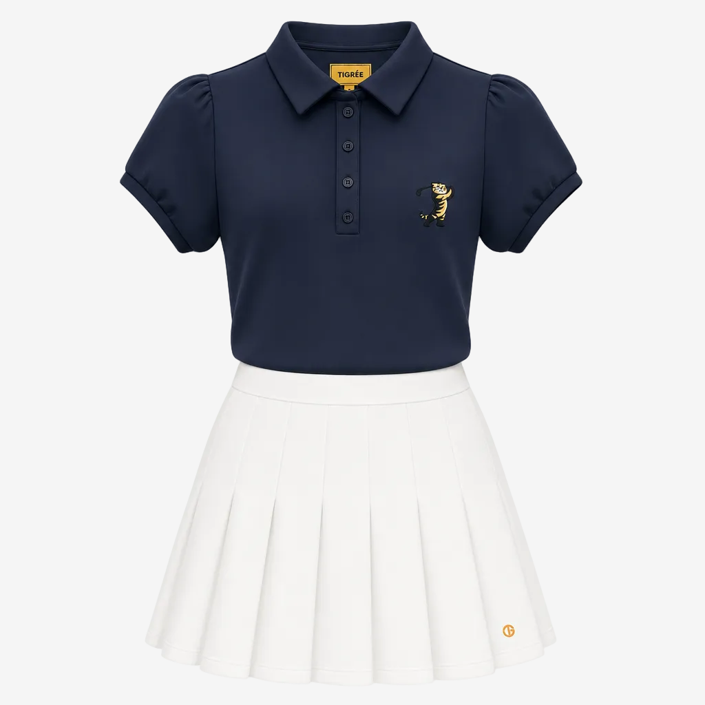 A girls' two-piece uniform set featuring a navy blue short-sleeve polo shirt with a small embroidered tiger logo on the left chest, paired with a white pleated skirt. The collar label and the skirt hem both display the 'TIGRE' brand logo.