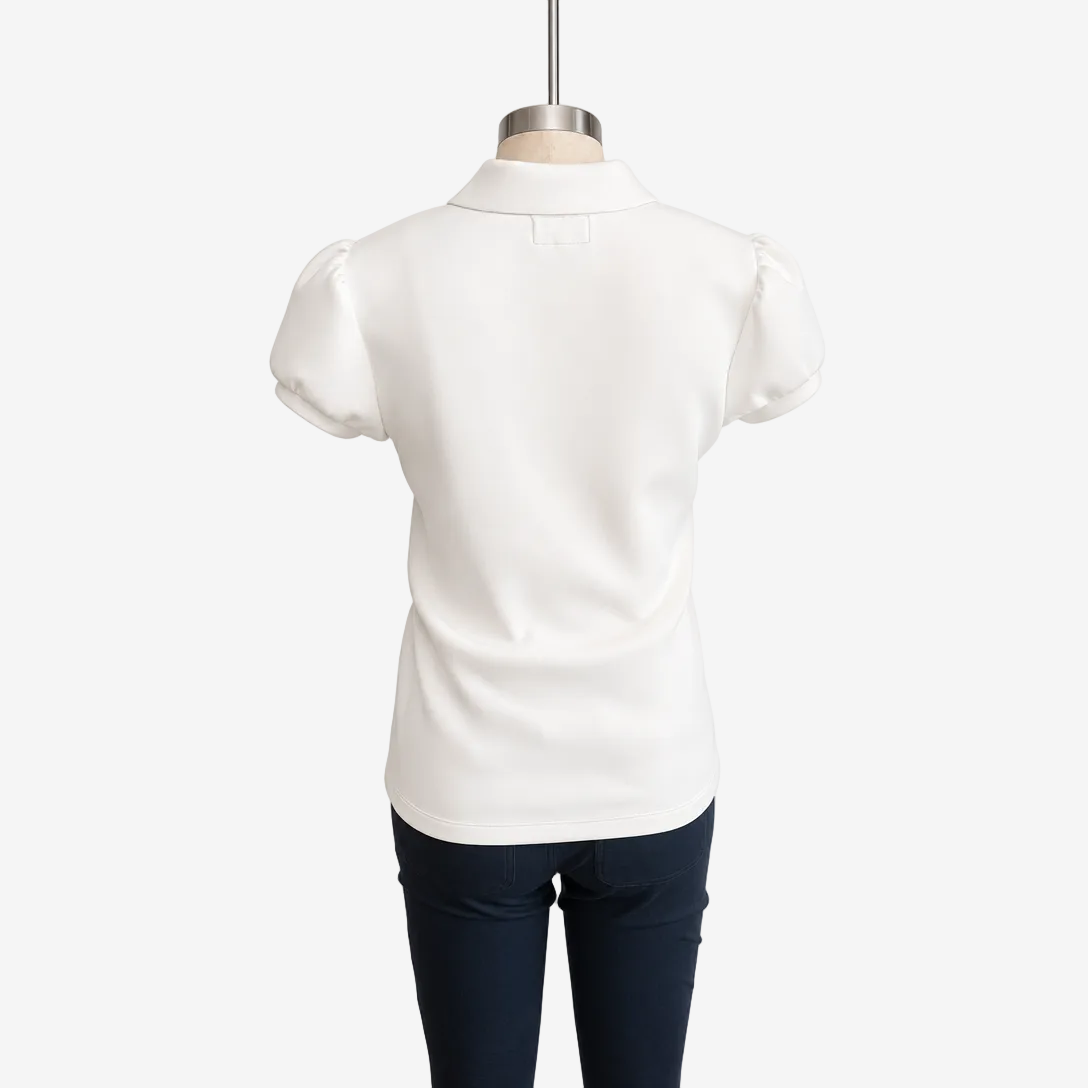 White short-sleeve blouse with puffed sleeves and a collar, shown from the back on a mannequin with dark navy pants against a white background.