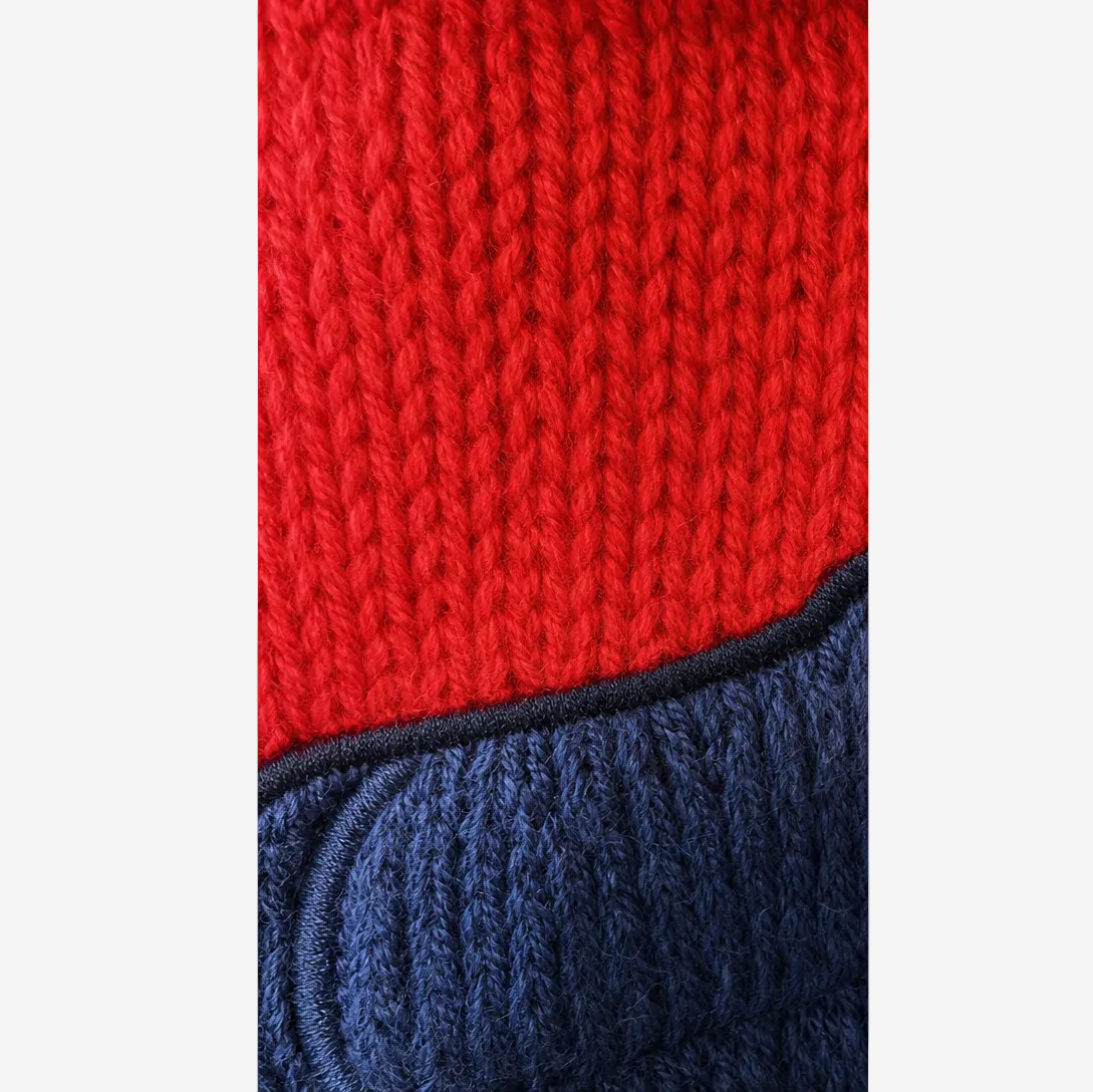 Close-up of red and navy knitted fabric with a textured pattern.