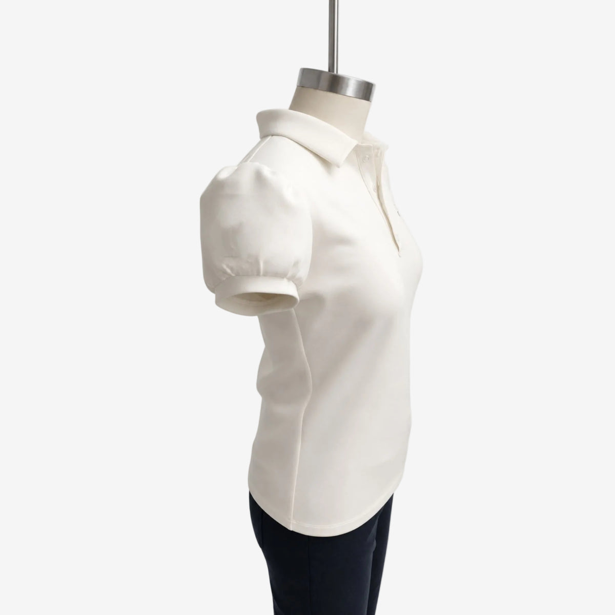 An off-white short-sleeve polo shirt with structured puff sleeves, displayed on a mannequin torso against a light gray background.
